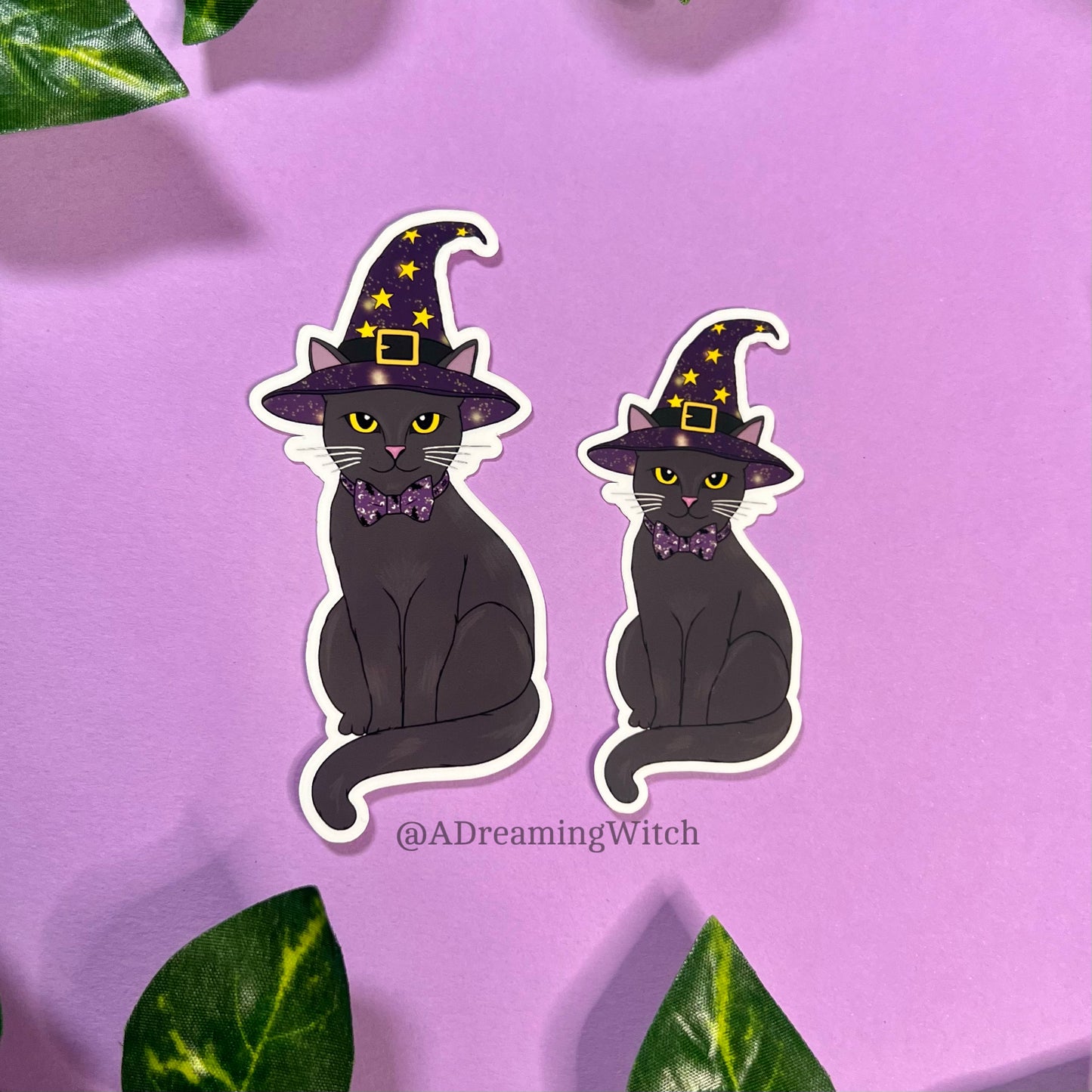 image of 2 stickers of black witchy cats, wearing a purple witch hat with yellow stars and celestial designs