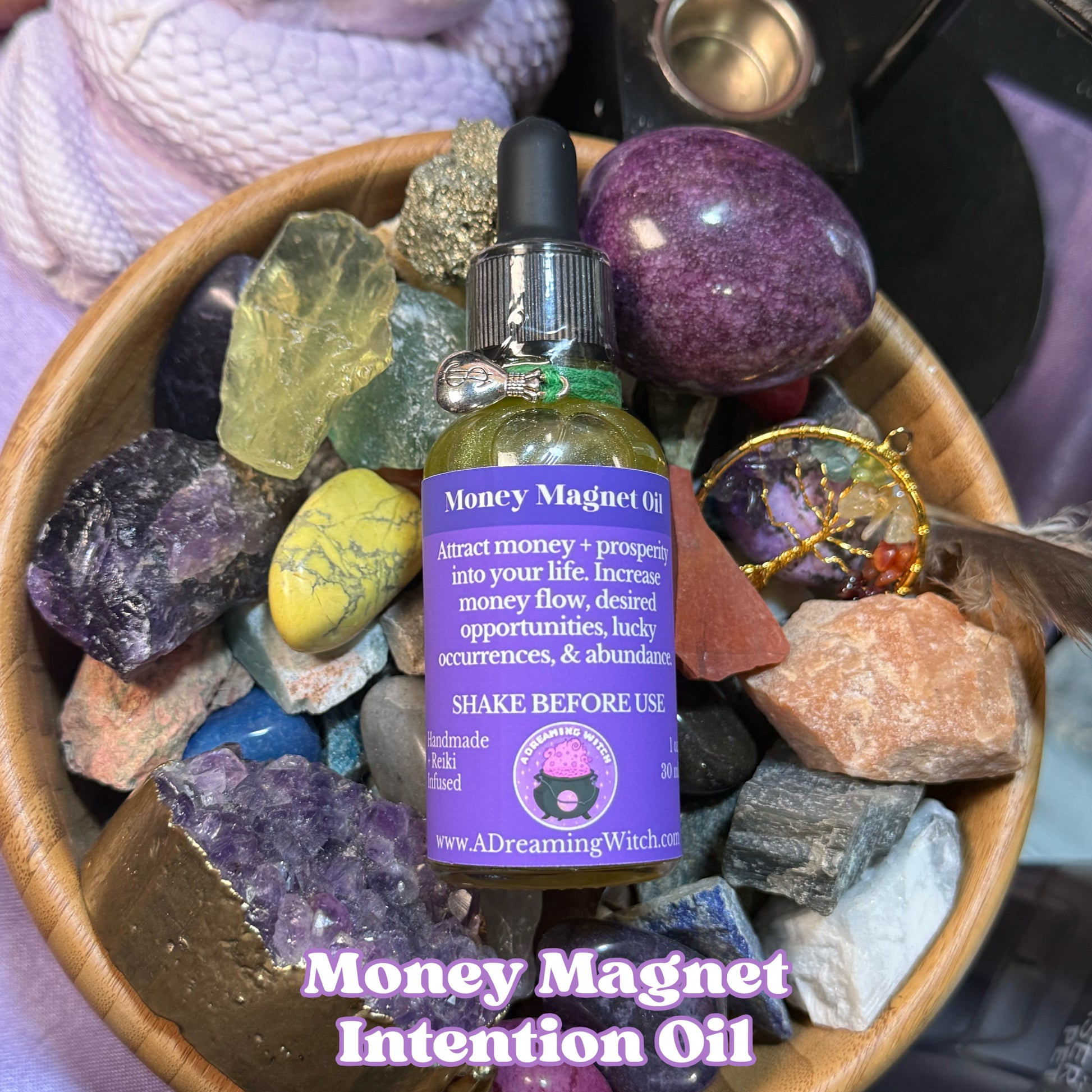 Money Magnet Intention Oil bottle with purple label on a bed of colorful crystals and stones.