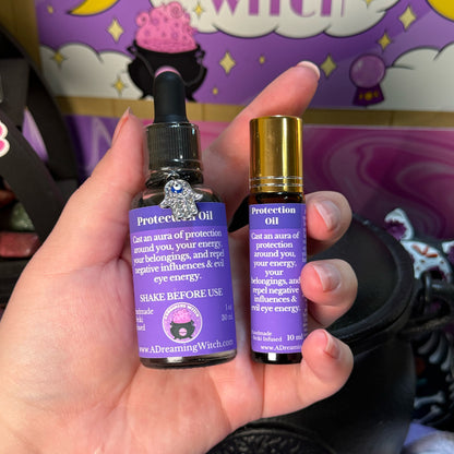 Two bottles of 'Protection Oil' held in a hand with a colorful background