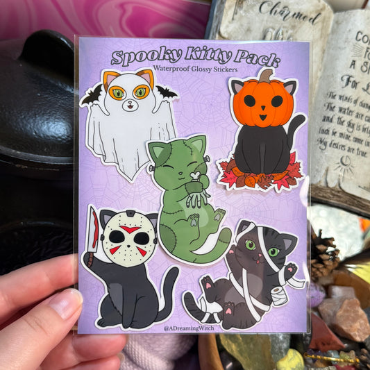 Spooky Kitty Pack stickers on a purple card held by a hand with a blurred background.