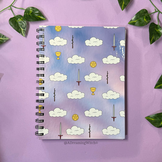 Notebook with tarot card symbols on a purple background